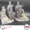 3D printed and painted models of two colossal ancient king statues. One wears a crown, the other a helmet, both hold an axe and have one hand raised. They are carved from stone with weathered textures and set on rocky bases with stairs.