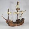 A fully painted 3D printed model of a 15th-century Caravel ship on a white background. The model features detailed wood textures, cannons, a mermaid figurehead, heraldic shields, masts with furled sails, and intricate rigging.