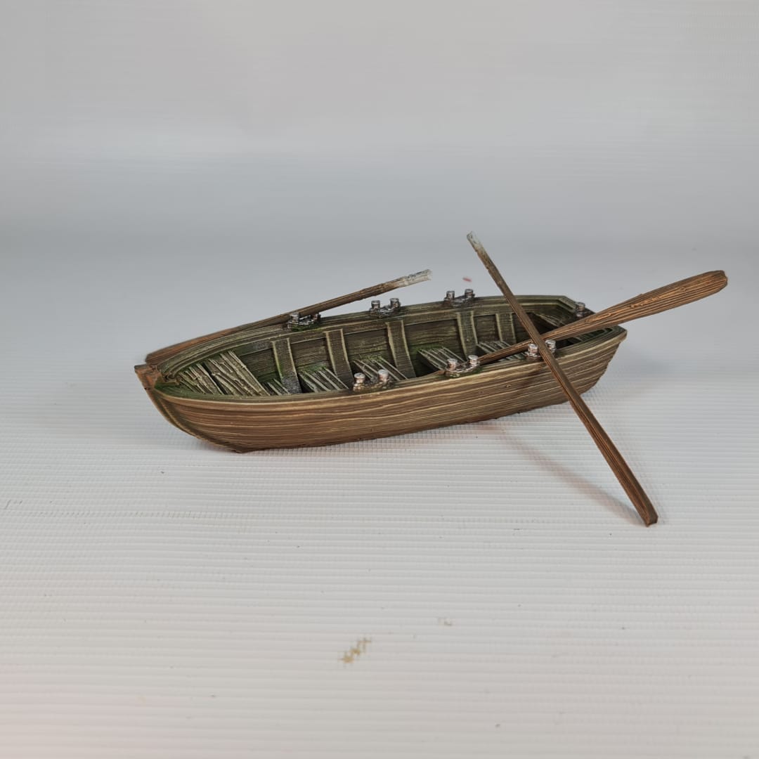 Painted 3D printed model of a classic wooden rowboat for tabletop wargaming, featuring detailed wood grain, benches, oars, and oarlocks on a white background.