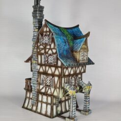 3D printed and painted model of a multi-story medieval fantasy house featuring half-timbered walls, a steep blue roof, stone pillars with lamps, and an external wooden staircase.